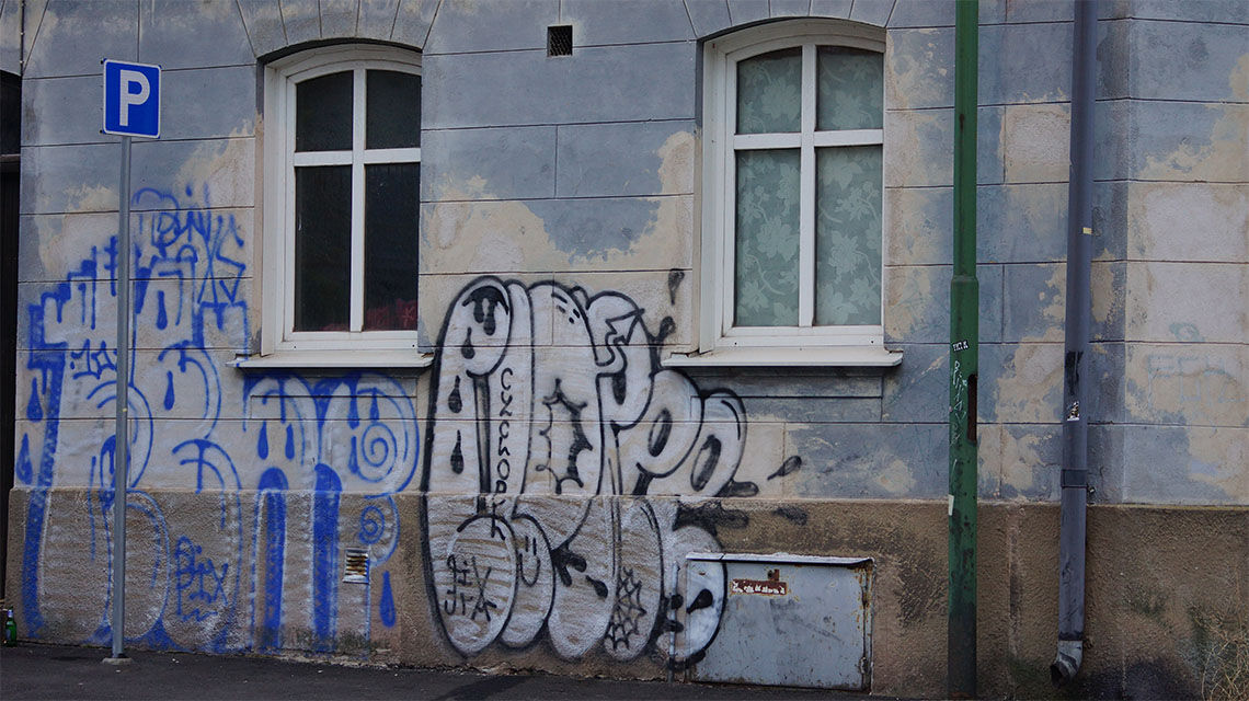 Graffiteja vanhan talon julkisivussa.